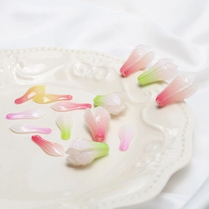 Gradient petal and magnolia bud charms for DIY jewelry making on a white plate