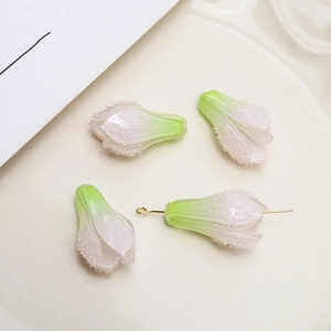 Macro detail of gradient pink and green magnolia bud pendants in a ceramic tray