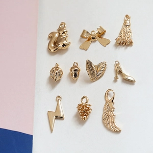 Détail de breloques dorées comprenant écureuil et escarpin pour la création de bijoux DIY