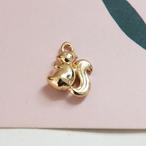 Détail macro d'un pendentif écureuil doré texturé pour la création de bijoux DIY