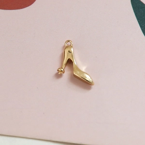 Détail d'un pendentif chaussure à talon doré avec base de sertissage pour bijoux
