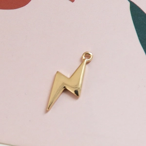 Gros plan d'un pendentif éclair doré poli pour la création de bijoux DIY à la main