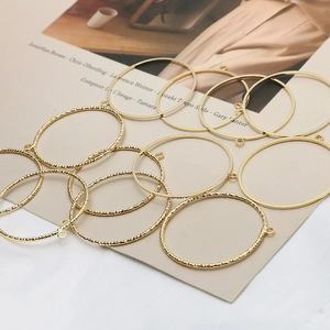 Detailed macro view of gold plated hollow round pendants with smooth and twisted metal textures