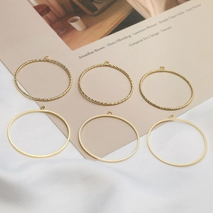 Macro view of gold plated round frame charms with smooth and twisted textures for DIY jewelry