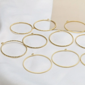 Macro shot of gold-plated hollow round pendants with hammered and smooth textures for DIY