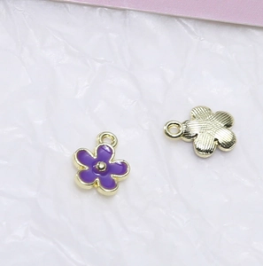 Detail von lila Emaille-Blütenanhängern mit Goldfinish für DIY-Schmuckherstellung