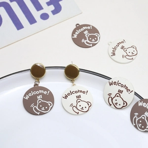 Close-up of cartoon bear alloy earrings with brown and white pendant accessories
