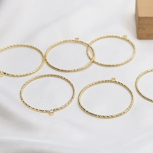 Macro detail of textured gold-plated hollow rings for DIY earring and jewelry making
