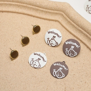 Macro detail of cute bear alloy earrings DIY parts with Welcome Hi message on tray