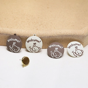 Detailed view of round enamel bear charms and gold stud accessories for DIY jewelry making