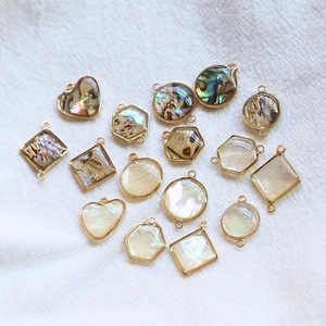 Détail de pendentifs géométriques en nacre d'abalone dorés pour bijoux DIY