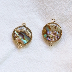 Détails macro de connecteurs en nacre d'abalone dorée pour la création de bijoux DIY