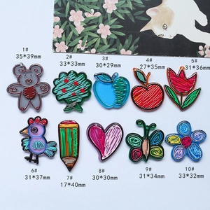 Detailed view of hand-drawn acrylic pendants including bear, bird, and apple for DIY crafts