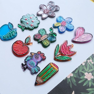 Macro detail of hand-drawn acrylic charms with glossy finish for DIY phone cases