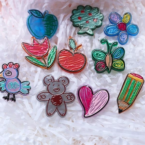 Macro shot of 10 colorful hand-drawn acrylic charms for DIY keychains and jewelry making