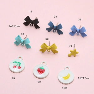 Flat lay of colorful DIY bow charms and fruit pendants on a pink background