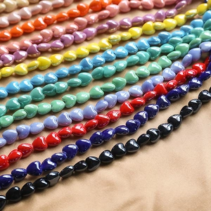 Close-up of colorful heart-shaped ceramic beads for DIY jewelry making with glazed finish