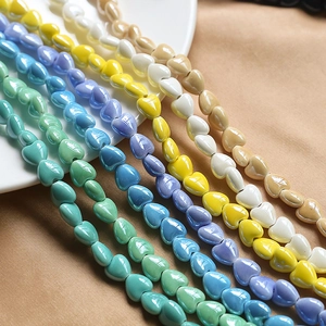 Macro shot of colorful ceramic heart beads in macaque colors on a white display plate