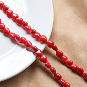 Macro shot of glossy red ceramic heart beads for DIY necklace and bracelet jewelry making