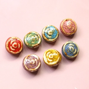 Flat lay of retro handmade ceramic floral beads for DIY jewelry making in various colors