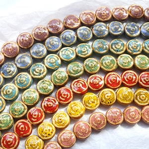 Macro view of assorted colorful ceramic beads featuring embossed floral relief patterns
