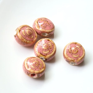 Macro shot of five pink handmade ceramic beads with brown speckles for DIY jewelry making