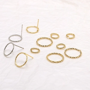 Macro shot of 18k gold plated round stud earrings and open jump rings for DIY jewelry