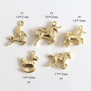 Detail view of five assorted golden unicorn and horse charms for DIY jewelry making