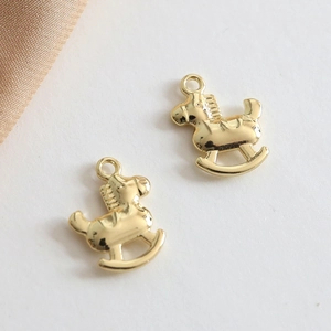 Close-up of golden rocking horse charms with polished finish and integrated hanging loops
