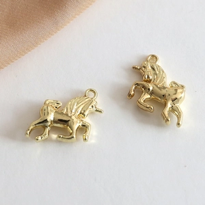 Macro shot of gold-plated unicorn charms for DIY necklaces with smooth polished finish