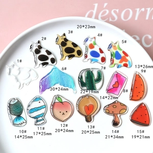 Detail of colorful acrylic charms including cats and fish icons for DIY jewelry making