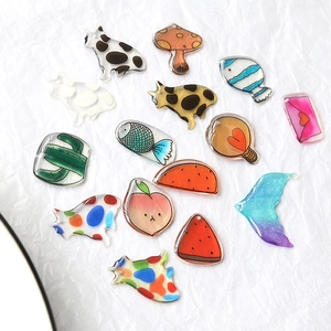 Close-up of cute translucent acrylic charms including cats, fish, and cactus for DIY jewelry