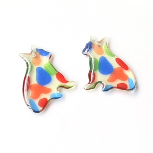 Detail view of translucent cat-shaped resin charms with vibrant artistic color splashes