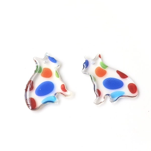 Close-up of translucent cat-shaped acrylic charms with colorful dots for DIY jewelry