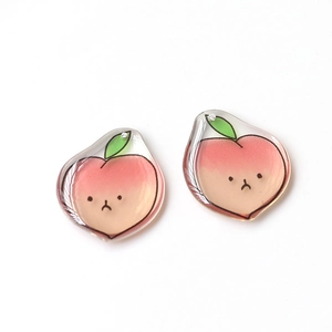 Close-up of translucent pink peach charms with green leaves for DIY jewelry making