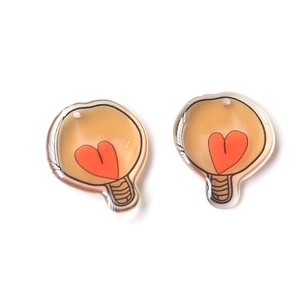 Macro shot of translucent light bulb pendants with orange heart design for DIY crafts