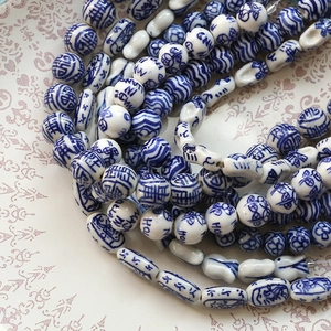 Close-up of blue and white porcelain beads with traditional Chinese longevity patterns
