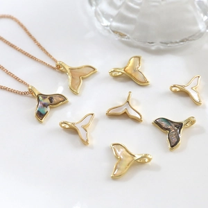 Détail de pendentifs queue de poisson avec nacre et chaînes plaquées or