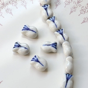 Macro detail of tulip-shaped blue and white porcelain beads for DIY jewelry making