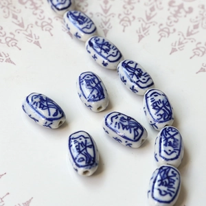 Macro shot of oval blue and white porcelain beads with vintage Chinese folk patterns