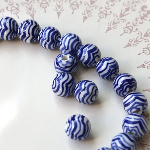 Macro shot of vintage blue and white porcelain beads with elegant wave patterns