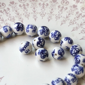 Macro detail of blue and white ceramic beads with floral patterns for DIY jewelry making