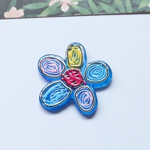 Blue flower shaped acrylic charm with colorful hand-painted spiral doodle design