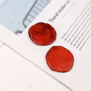 Close-up of irregular resin earring charms with smoky marble texture and wavy edges