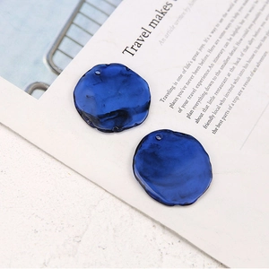 Detail of dark blue irregular resin pendants with marble texture for DIY jewelry making