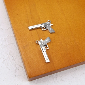 Macro shot of silver antique style pistol charm pendant for DIY jewelry making crafts