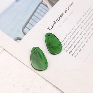Macro detail of green marbled resin teardrop pendants for DIY jewelry making