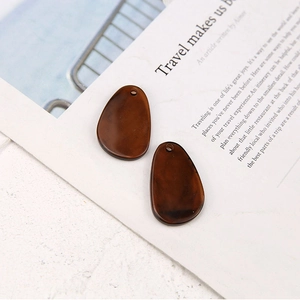 Close-up of translucent amber resin irregular pear-shaped pendants for DIY earring making