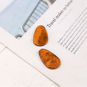 Close-up of translucent amber resin teardrop pendants for DIY jewelry earring making