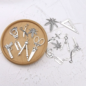 Antique silver alloy charms set featuring scissors, gun and leaf shapes for DIY jewelry